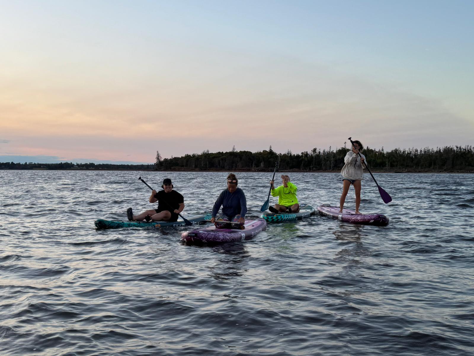 Group of paddlers on calm water at dusk, representing flexible rental options