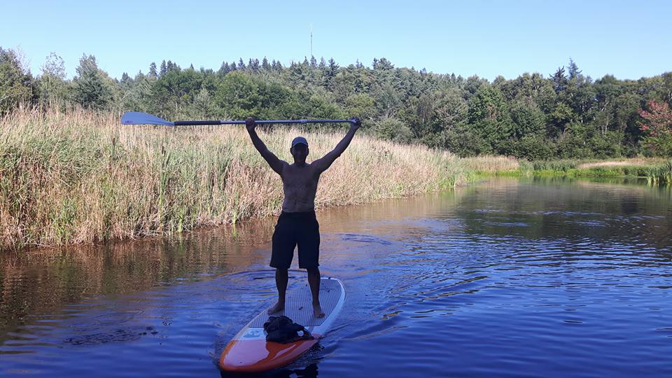 Paddler on a calm river, representing delivery service area